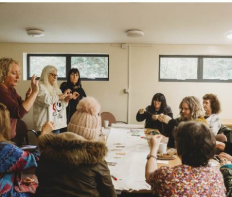 Women learning together around a table during The Change programme