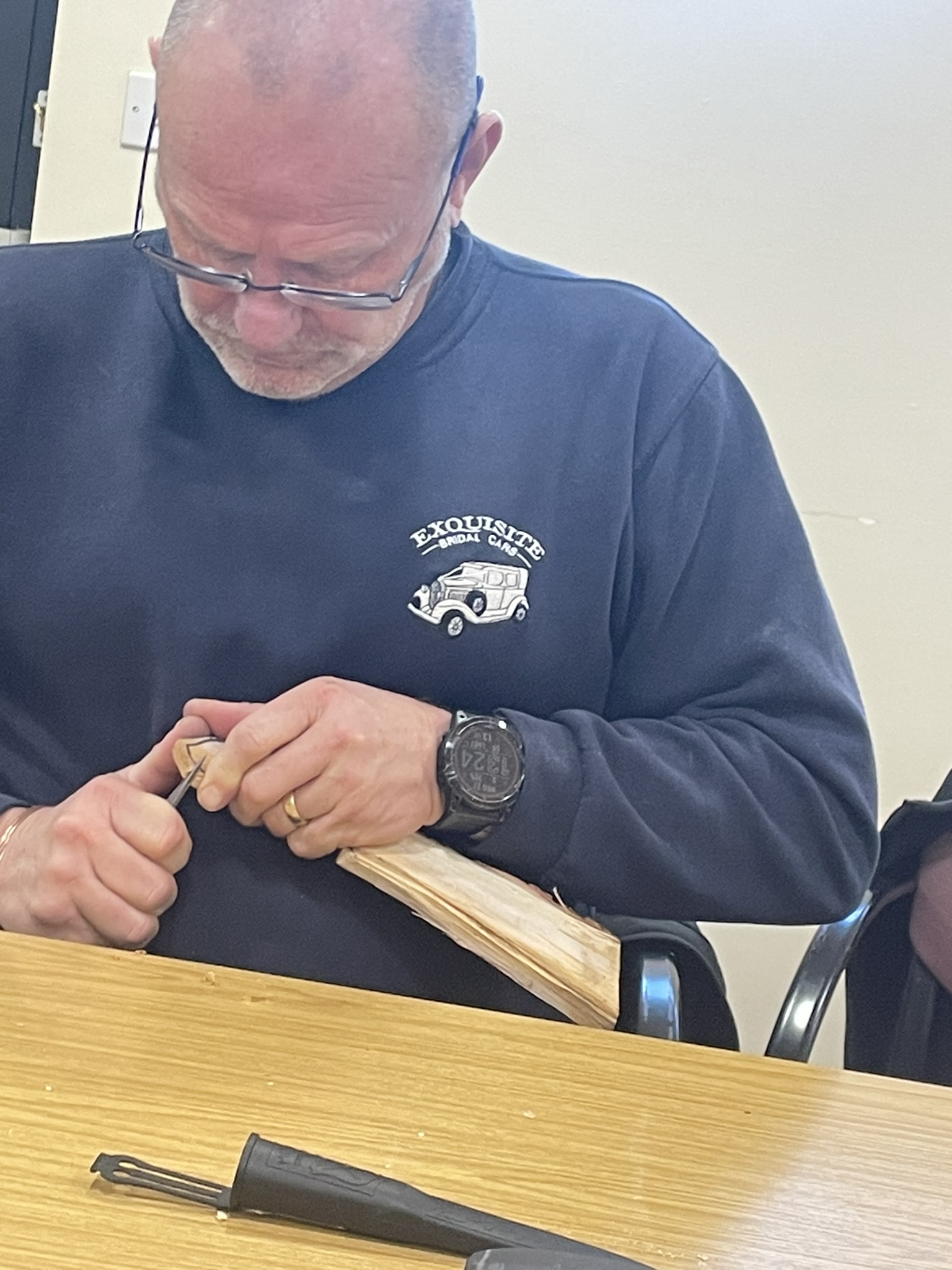 A participant concentrating on a woodcraft project indoors